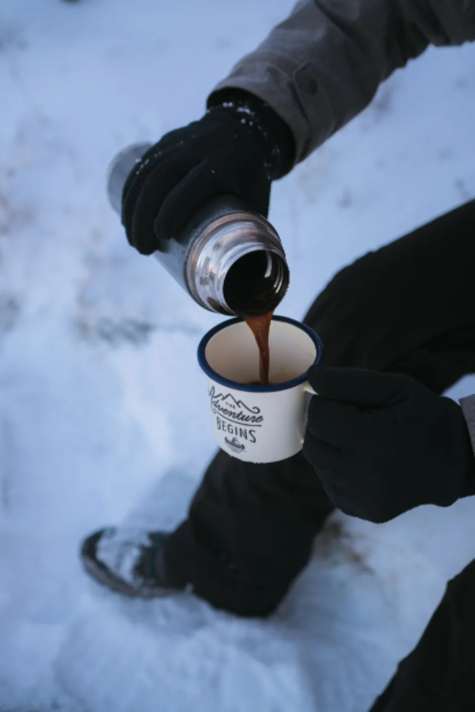 Café servido da garrafa térmica na neve, cena comum no inverno da Noruega