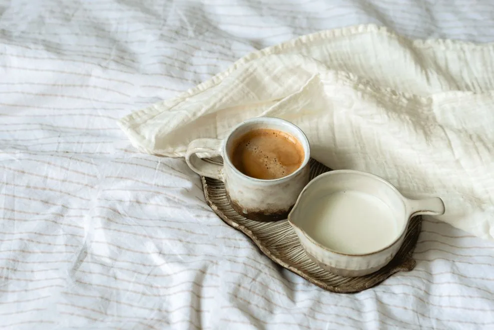 Xícara de café ao lado de uma pequena leiteira