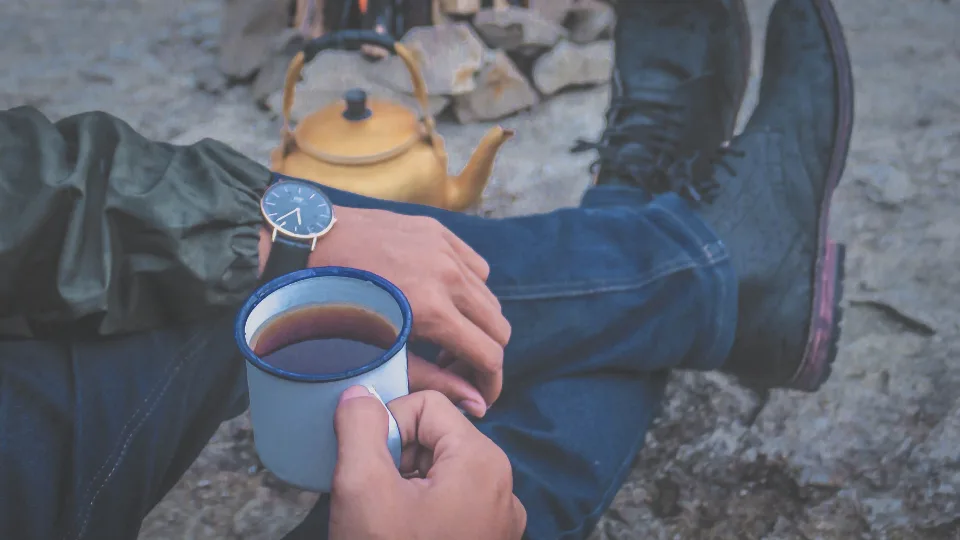 Caneca de café esmaltada ao lado da chaleira na fogueira, espírito do kokekaffe norueguês