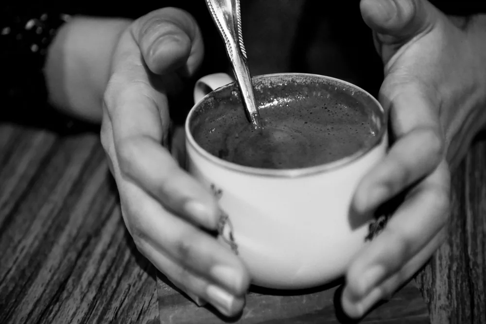 Colher ao lado de uma xícara de café