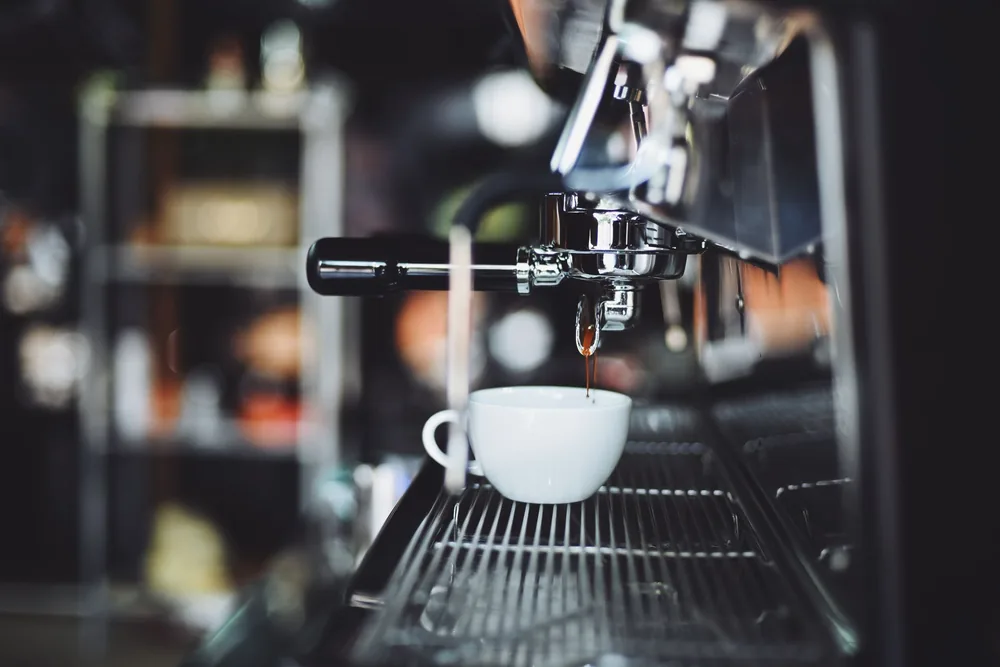 Café espresso saindo da máquina para a xícara