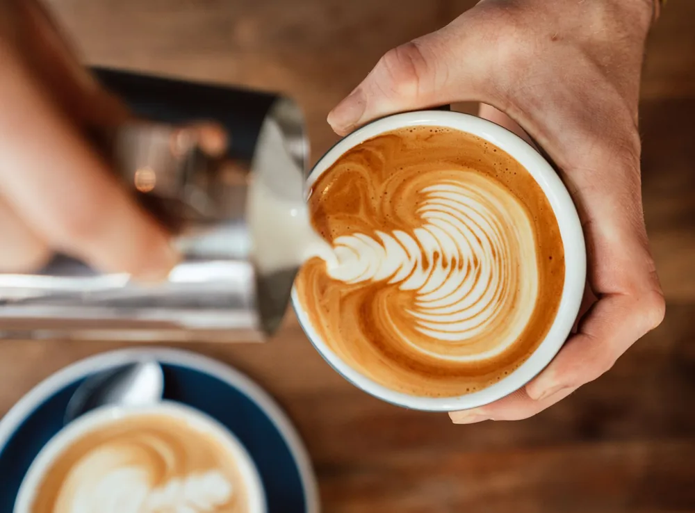 Barista despejando o leite