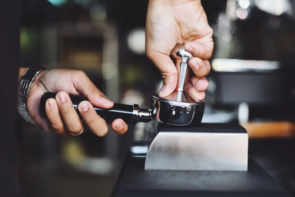 Tamper e pressão: por que o barista aperta o pó do espresso